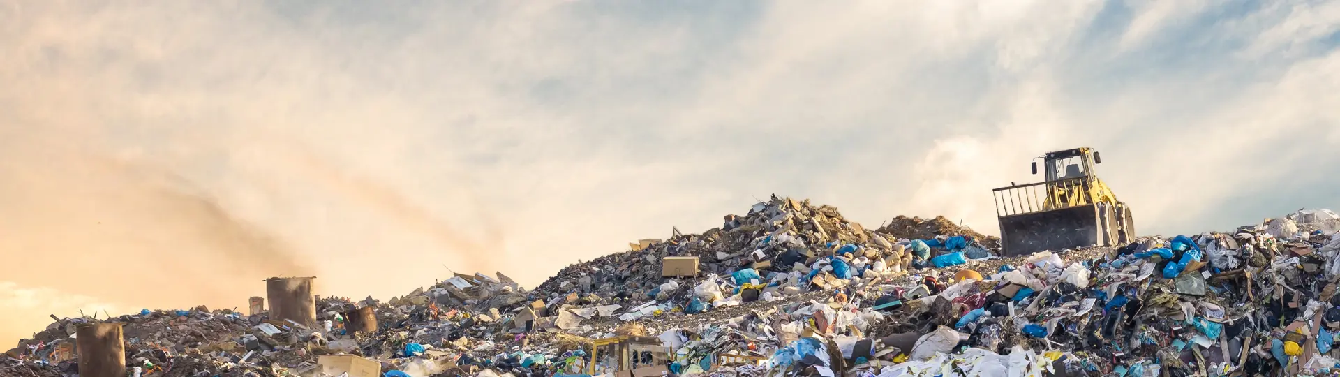 Bulldozer at a landfill site full of plastic