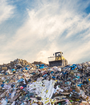 Bulldozer at a landfill site full of plastic